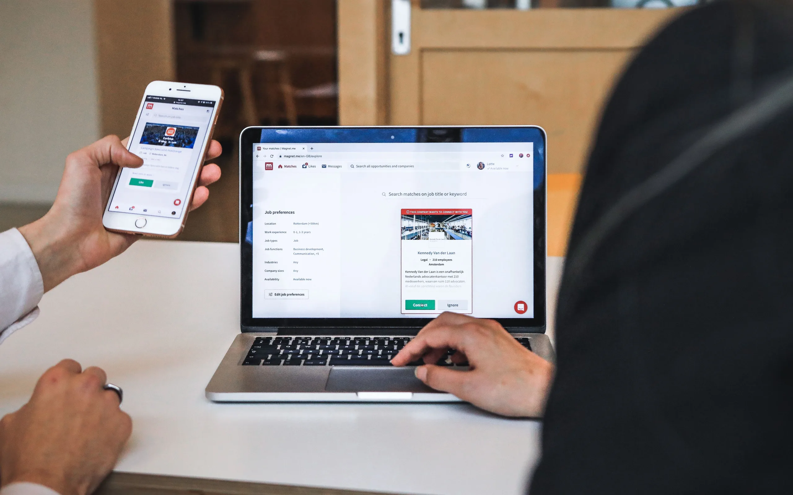 Mains sur un smartphone et un ordinateur portable pour comparer des offres d’assurance en ligne